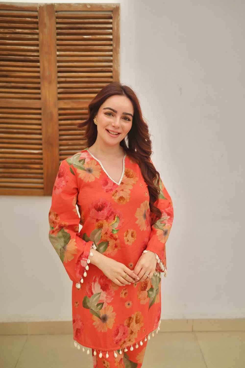 Close-up of lace work on orange kurti sleeves