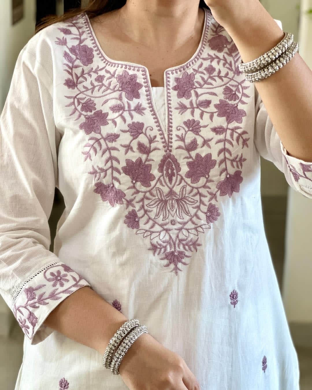 Close-up of neckline embroidery on white kurti