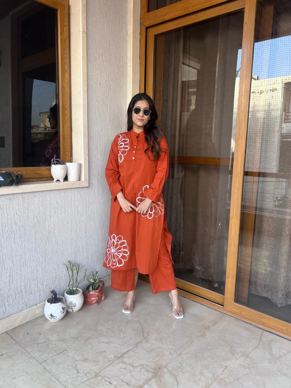 Full set of orange kurti and matching pants styled on a model.