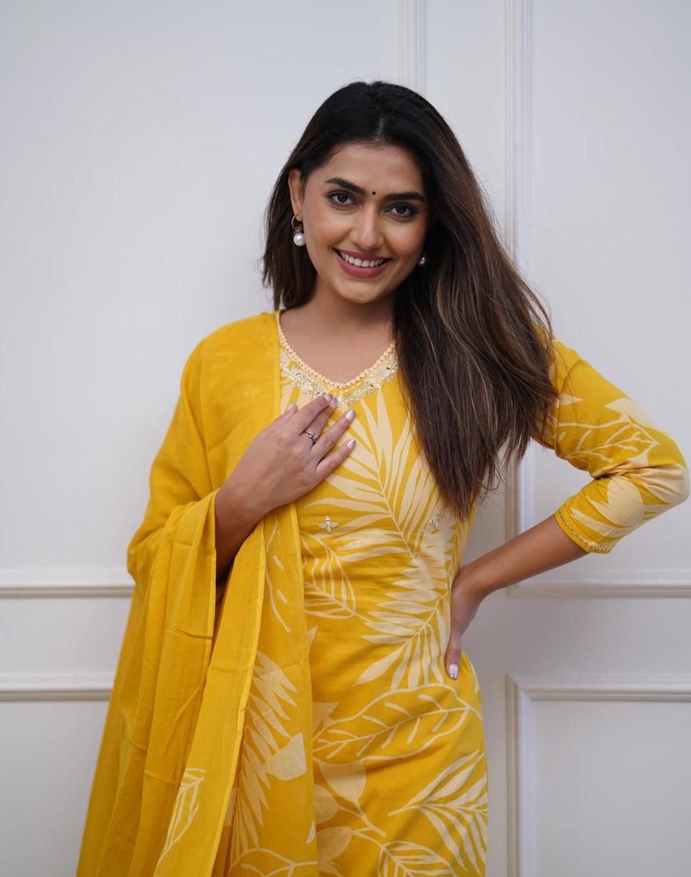 Elegant yellow muslin kurti with delicate sequin detailing, styled with straight pants and a dupatta for a graceful ethnic outfit.