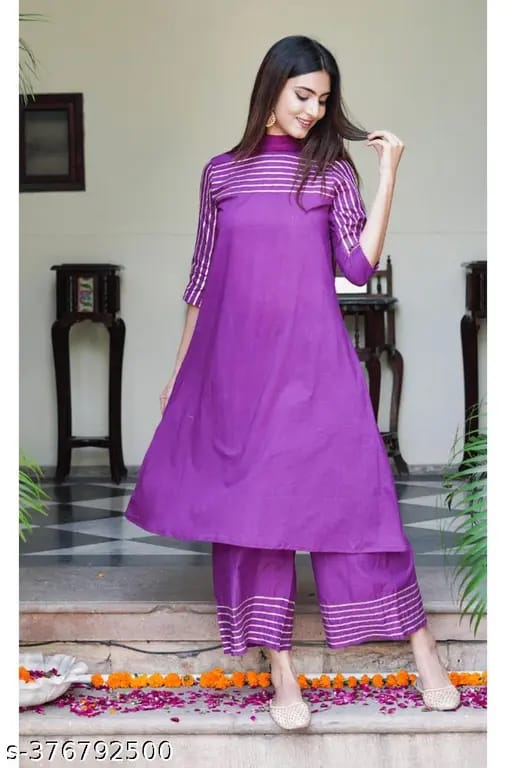  Festive purple kurti with intricate gota lace work, styled with complementing pants and a dupatta for an elegant ethnic look.