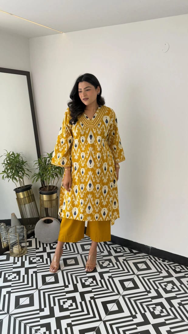 Yellow embroidered cotton kurti set with lace detailing on the neckline

